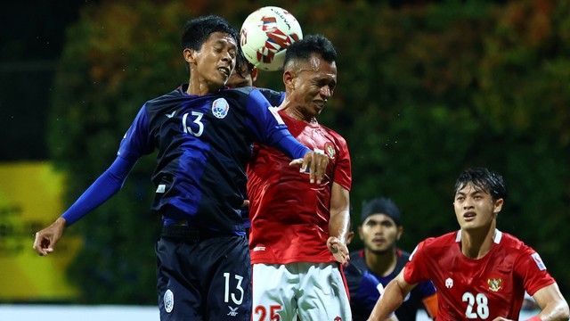Pemain Timnas Kamboja Min Ratanak beraksi dengan Pemain Timnas Indonesia Irfan Samaling Kumi pada pertandingan Grup B AFF Suzuki Cup di Stadion Bishan, Singapura, Kamis (9/12). Foto: Yong Teck Lim/Getty Images