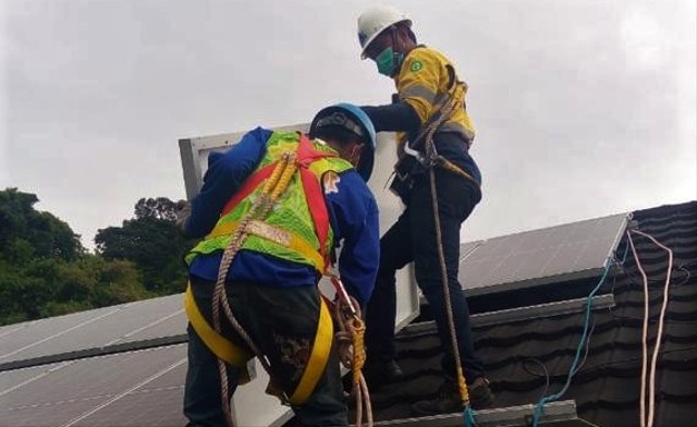 Petugas tengah memasang panel solar cell di PT Semen Padang. Foto: istimewa