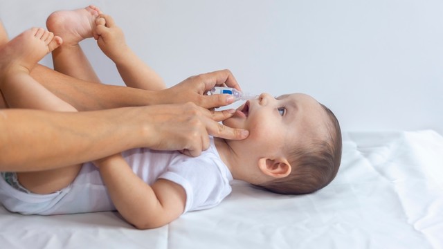 Meneteskan obat ke hidung bayi. Foto: Shutterstock.