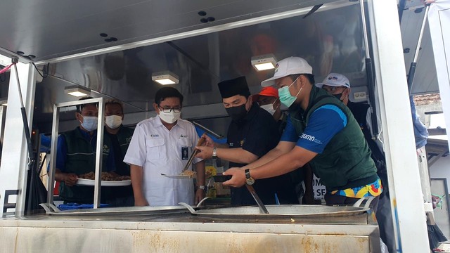 Menteri BUMN Erick Thohir ikut menyiapkan makanan di food truck PLN untuk pengungsi korban erupsi Gunung Semeru di Lumajang, Jawa Timur, Minggu (12/22). Foto: PLN