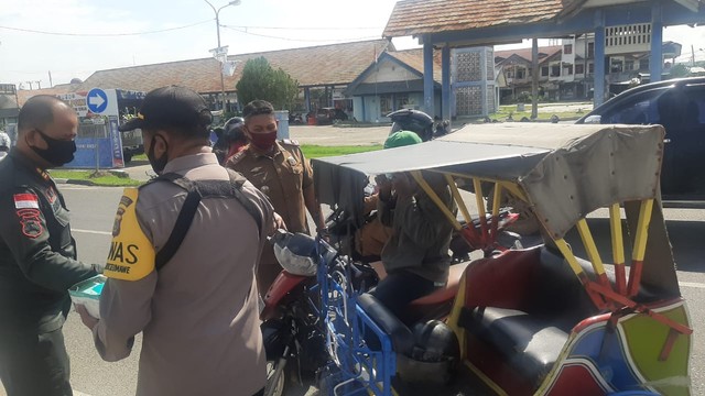 Petugas gabungan menghentikan pengendara yang melintas tanpa memakai masker saat menggelar razia prokes di Kota Lhokseumawe, Aceh. Foto: Dok. Polres Lhokseumawe