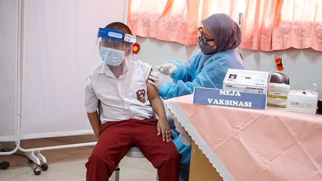Tenaga kesehatan menyuntikkan vaksin COVID-19 kepada pelajar di SDN Cempaka Putih Timur 03, Jakarta, Selasa (14/12/2021). Foto: Iqbal Firdaus/kumparan