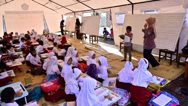 Anak-anak belajar ditenda darurat di Sumbermujur, Candipuro, Lumajang, Jawa Timur, Selasa (14/12/2021). Foto: Budi Candra Setya/Antara Foto