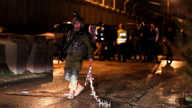 Pasukan Israel berkumpul di lokasi serangan penembakan di dekat pos terdepan pemukim Yahudi, dekat Nablus, di Tepi Barat yang diduduki, Kamis (16/12). Foto: Ammar Awad/REUTERS