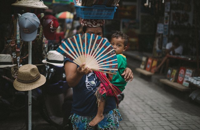 Seorang Ibu Berjualan Kipas di Ubud Bali dan Mengasuh Anak Sekaligus/Sumber Foto: Unsplash/Tbel A