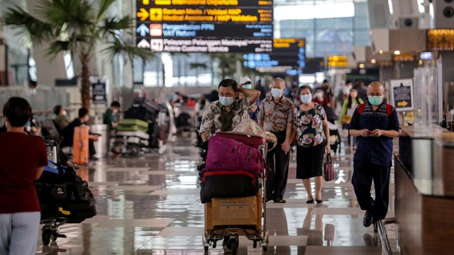 Sejumlah penumpang pesawat berjalan di area Terminal 3 Bandara Internasional Soekarno Hatta, Tangerang, Banten, Jumat (17/12/2021). Foto: Fauzan/ANTARA FOTO