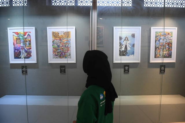 Pengunjung memerhatikan lukisan yang dipajang dalam pameran Membangun Harmoni di Museum Basoeki Abdullah, Jakarta, Sabtu (18/12). Foto: Akbar Nugroho Gumay/ANTARA FOTO