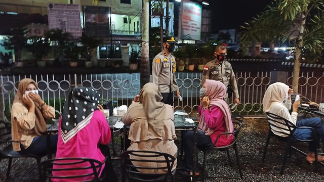 Tim razia prokes di Lhokseumawe, Aceh, menyosialisasikan vaksin COVID-19 ke pengunjung kafe, dan juga memantau penerapan protokol kesehatan. Foto: Dok. Polres Lhokseumawe