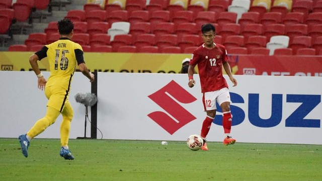 Pemain Timnas Indonesia Pratama Arhan mencoba melewati pemain Timnas Malaysia pada pertandingan Piala AFF di Stadion Nasional, Singapura.
 Foto: PSSI
