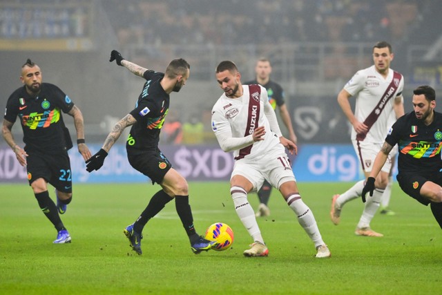 Pemain Inter Milan Marcelo Brozovic berusaha merebut bola dari pemain Torino pada pertandingan lanjutan Liga Italia di Stadion San Siro, Milan, Italia. Foto: Miguel MEDINA / AFP