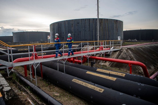 Pekerja PT Pertamina Hulu Rokan mengecek saluran pipa minyak yang menuju tangki pengumpul produksi minyak (Tank Farm) di Blok Rokan, Dumai, Riau, Rabu (22/12/2021). Foto: Nova Wahyudi/Antara Foto