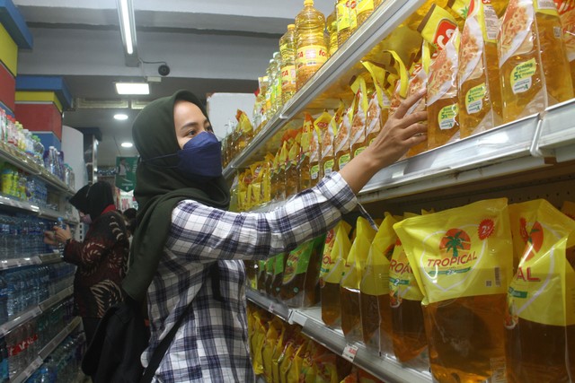 Seorang pengunjung memilih minyak goreng yang dijual di supermarket. Foto: ANTARA FOTO/Jessica Helena Wuysang