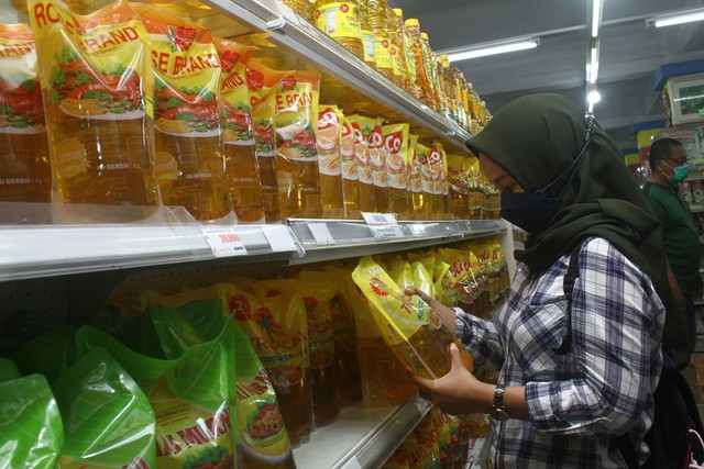 Seorang pengunjung memilih minyak goreng yang dijual di supermarket. Foto: ANTARA FOTO/Jessica Helena Wuysang