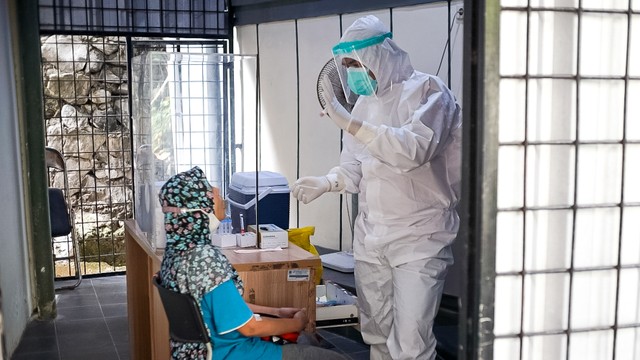 Petugas kesehatan bersiap melakukan tes swab kepada warga di pos screening Puskesmas Kecamatan Mampang Prapatan, Jakarta Selatan, Selasa (28/12/2021). Foto: Iqbal Firdaus/kumparan