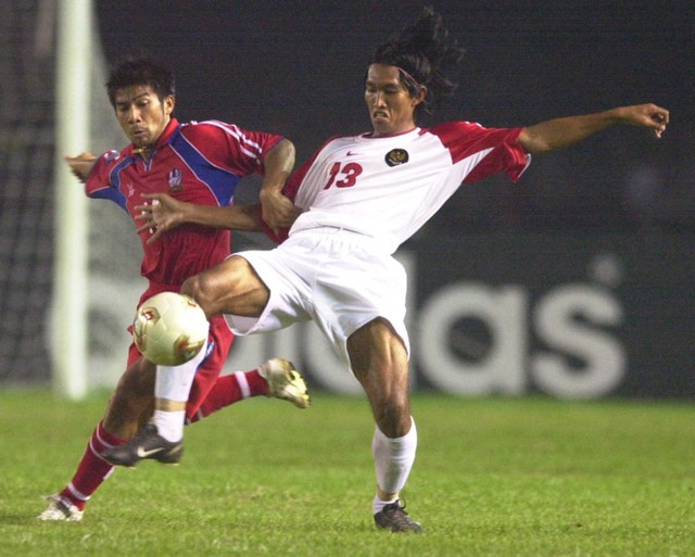 Pemain Thailand Sakda Joemdee (kiri) dan Budi Sudarsono (kanan) dari Indonesia berebut bola pada final Tiger Cup 2002 di stadion olahraga Gelora Bung Karno di Jakarta 29 Desember 2002. Foto: Weda/AFP