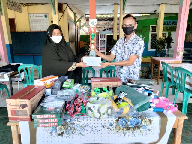 Dedi Hendriyanto (kanan), fasilitator daerah Program PINTAR Tanoto Foundation menyerahkan hadiah lomba video duta orangtua kepada Wakil Kepala Sekolah bidang Kurikulum SMPN 21 Batang Hari, Lidya Aprianti, S.Pd, Kamis, (30/12).