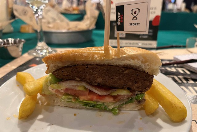 Hamburger nabati, dimasak oleh robot yang dikembangkan oleh perusahaan teknologi makanan Israel, SavorEat, disajikan di sebuah restoran. Foto: STEVEN SCHEER/REUTERS