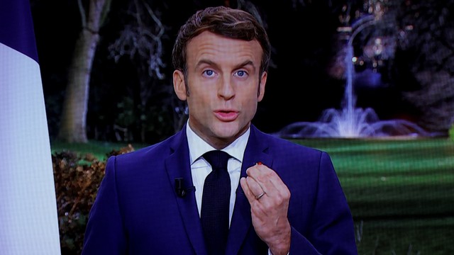 Presiden Prancis Emmanuel Macron terlihat di layar saat menyampaikan pidato Tahun Baru kepada bangsa di Istana Elysee di Paris, Prancis, Jumat (31/12). Foto: Christian Hartmann/REUTERS