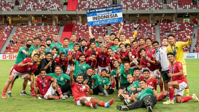 Sejumlah pesepak bola dan tim pelatih Timnas Indonesia berfoto bersama usai pengalungan medali Piala AFF 2020 di National Stadium, Singapura, Sabtu (1/1/2022). Foto: Flona Hakim/ANTARA FOTO
