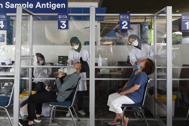 Petugas melakukan swab test antigen kepada calon penumpang kereta api di Stasiun Gambir, Jakarta, Minggu (2/1/2022).  Foto: ANTARA FOTO/Hafidz Mubarak A