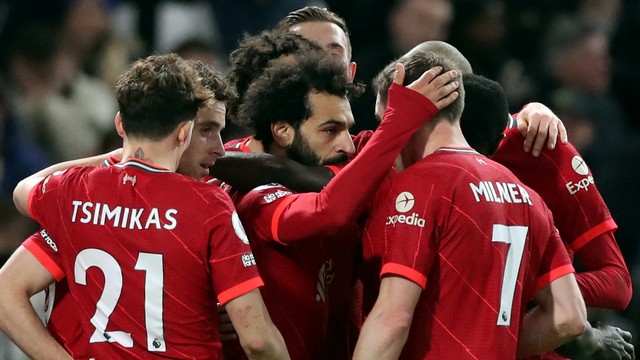 Pemain Liverpool Mohamed Salah berselebrasi dengan rekan James Milner dan rekan setimnya usai mencetak gol kedua mereka ke gawang Chelsea di Stamford Bridge, London, Inggris, Minggu (2/1/2022). Foto: Action Images via Reuters/Peter Cziborra