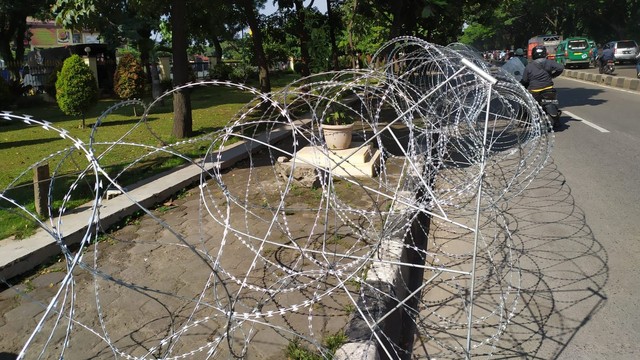 Kawat berduri terpasang di pagar depan Mapolda Jabar jelang pemeriksaan Habib Bahar bin Smith pada Senin (3/1).  Foto: Rachmadi Rasyad/kumparan