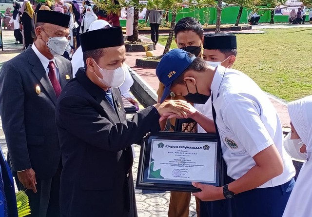 Kepala Kemenag M. Kadir Aziz Al Yafie saat memberikan penghargaan kepada siswa berprestasi. Foto: kendarinesia/Lukman Budianto