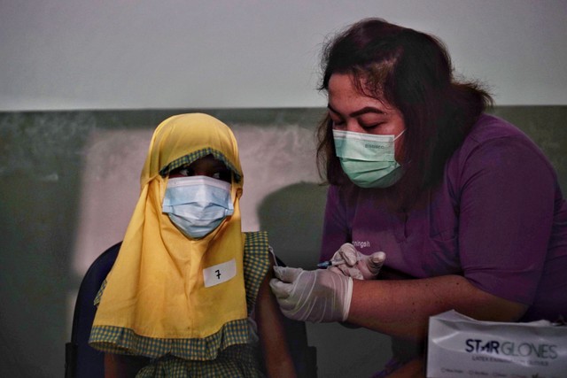 Tenaga kesehatan menyuntikan vaksin COVID-19 khusus untuk anak. Foto: Jamal Ramadhan/kumparan