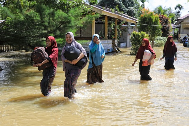 Warga menyelamatkan barang-barang dan mengungsi di Kecamatan Syatalira Aron, Aceh Utara. Foto: Azwar Ipank untuk acehkini 