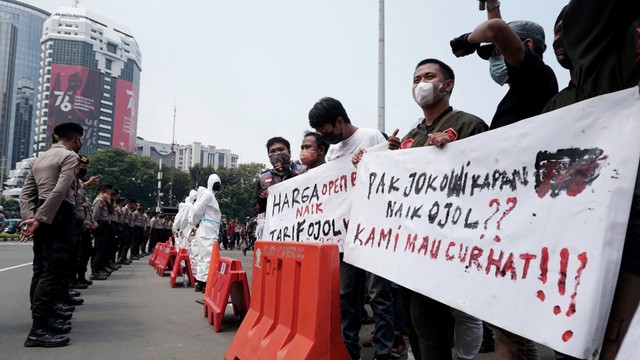 Massa gabungan dari Ojek online (Ojol) melakukan unjuk rasa di luar kawasan Monumen Nasional, Jakarta, Rabu (5/1/2022). Foto: Jamal Ramadhan/kumparan