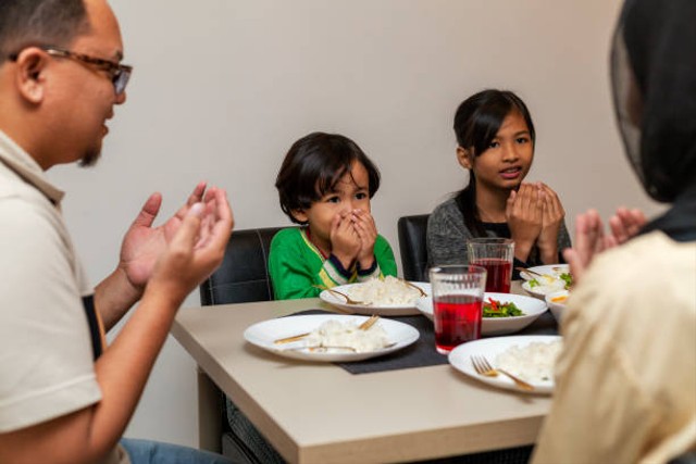 Ilustrasi sebuah keluarga sedang berdoa sebelum berbuka puasa. Foto: iStock