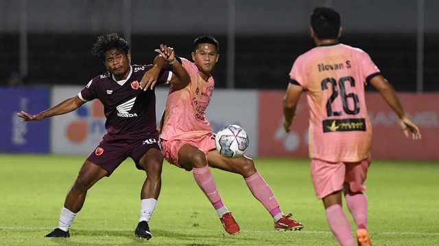 Pemain Madura United Fadilla Akbar (tengah) berebut bola dengan pemain PSM Makassar Ilham Udin Aramiyn dalam pertandingan sepak bola Liga 1 di Stadion Kompyang Sujana, Denpasar, Bali, Sabtu (8/1/2022). Foto: Nyoman Budhiana/ANTARA FOTO