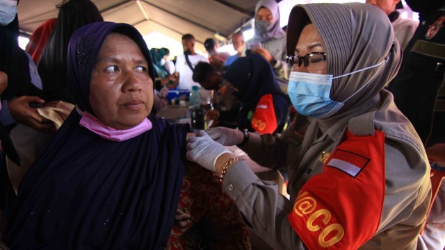 Petugas vaksinator tengah menyuntikan dosis vaksin kepada warga dalam kegiatan Sumdarsin di GOR H Agus Salim Padang, Sumatera Barat, Sabtu 30 Oktober 2021. Foto: Langakn/Kumparan