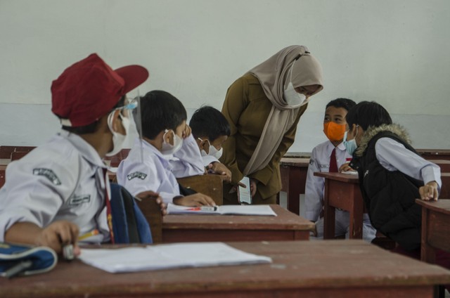 Sejumlah murid mengikuti pelaksanaan pembelajaran tatap muka (PTM) 100 persen di SDN 065 Cihampelas, Bandung. Foto: ANTARA FOTO/Novrian Arbi