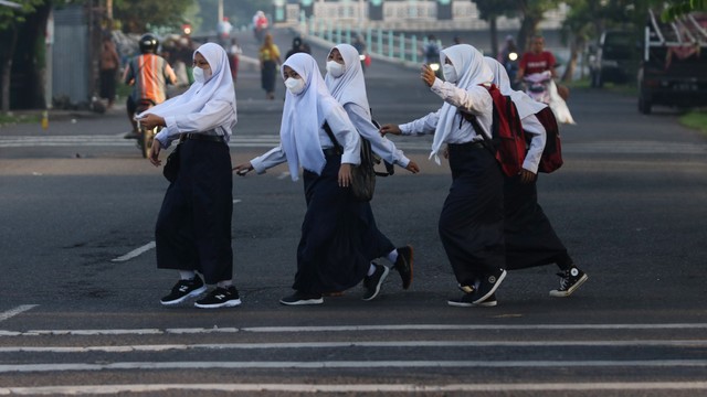 Sejumlah pelajar menyeberang jalan menuju ke sekolah. Foto: ANTARA FOTO/Didik Suhartono