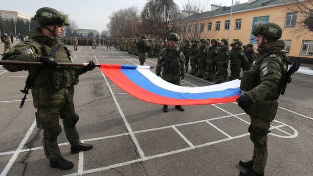 Prajurit Rusia mengibarkan bendera nasional saat upacara penarikan pasukan penjaga perdamaian Organisasi Perjanjian Keamanan Kolektif (CSTO) dari Kazakhstan, di Almaty, Kazakhstan, Kamis (13/1). Foto: Pavel Mikheyev/REUTERS