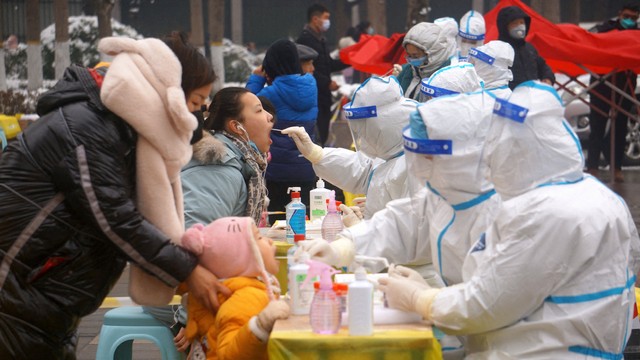 Petugas medis dengan pakaian pelindung mengumpulkan swab dari warga di lokasi pengujian asam nukleat selama pengujian massal putaran ketiga menyusul kasus penyakit virus corona (COVID-19) di wilayah Jishan Yuncheng, provinsi Shanxi, China. Foto: China Daily via REUTERS