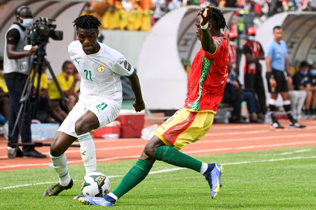 Pemain Senegal Ibrahima Mbaye berebut bola dengan pemain Guinea pada pertandingan Grup B Piala Afrika di Stade de Kouekong di Bafoussam, Kamreun. Foto: Pius Utomi EKPEI / AFP