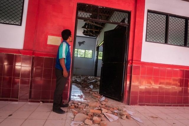 Petugas sekolah melihat kondisi ruang kelas yang rusak akibat gempa di SDN Kerta Mukti, Sumur, Pandeglang, Banten, Sabtu (15/1).  Foto: Muhammad Bagus Khoirunas/ANTARA FOTO