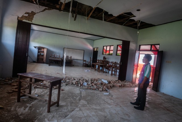 Petugas sekolah melihat kondisi ruang kelas yang rusak akibat gempa di SDN Kerta Mukti, Sumur, Pandeglang, Banten, Sabtu (15/1).  Foto: Muhammad Bagus Khoirunas/ANTARA FOTO