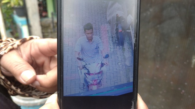 Warga menunjukan foto Kanipah alias Andre, suami Indah Safitri (27) yang diduga membunuh istrinya sendiri. Foto: Intan Alliva/kumparan