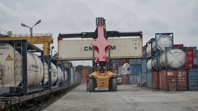 Alat berat menata peti kemas ke atas gerbong kereta api di Stasiun Jakarta Gudang, Jakarta Utara, Sabtu (15/1).  Foto: Jamal Ramadhan/kumparan