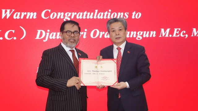 Direktur ASEAN-China Center (ACC) Chen Dehai (kanan) menganugerahkan gelar Profesor (HC) dari Dalian University of Foreign Language (DUFL), Dalian, Provinsi Liaoning, kepada Dubes RI untuk China Djauhari Oratmangun di Beijing, China, Senin (17/1). Foto: M. Irfan Ilmie/Antara Foto