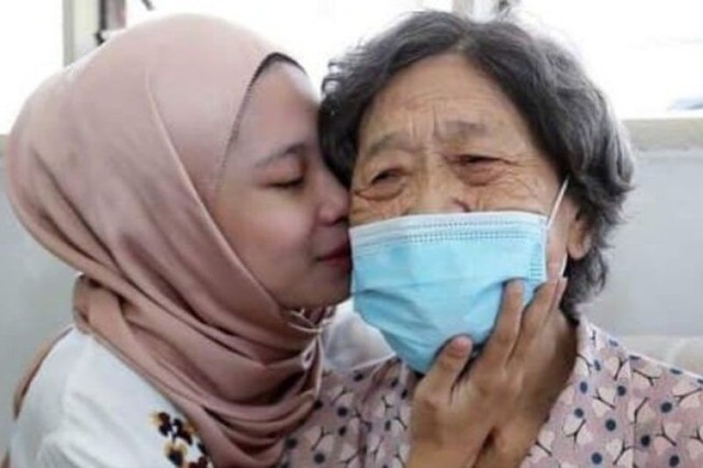 Rohana Abdullah (22) bersama ibu angkatnya, Chee Hoi Lan (83) di Kuala Lumpur, (17/1/2022). Foto: Harian Metro/Agus/via Antara