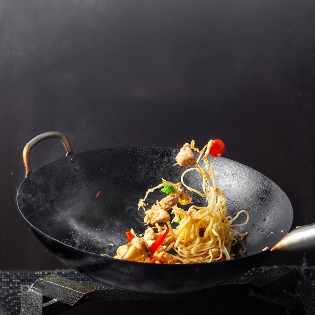 Foto: Cara mengolah makanan dengan menumis | Sumber: https://www.freepik.com/free-photo/side-view-spaghetti-frying-pan-black-background_7757585.htm