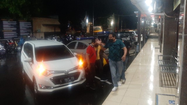 Suasana saat Hadfana Firdaus yang menendang sesajen di area Gunung Semeru digiring polisi ke dalam ruang tahanan Markas Kepolisian Resor Lumajang, Kamis (20/1/2022) malam. Foto: Dok. Istimewa