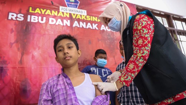 Seorang anak menerima suntik vaksin COVID-19 jenis Sinovac di Museum Aceh, Kamis (13/1). Foto: Suparta/acehkini