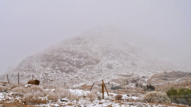 Warga Saudi mengunjungi Jabal al-Lawz (Gunung Almond) yang tertutup salju, di sebelah barat kota Tabuk, Saudi, Senin (17/1/2022). Foto: Ibrahim ASSIRI/AFP 
