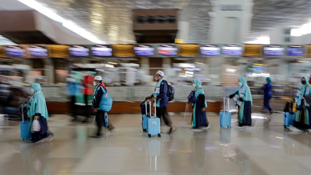 Sejumlah calon jemaah umrah berjalan sebelum menaiki pesawat di Terminal 3 Bandara Internasional Soekarno-Hatta, Tangerang, Banten, Sabtu (8/1/2022). Foto: Fauzan/ANTARA FOTO