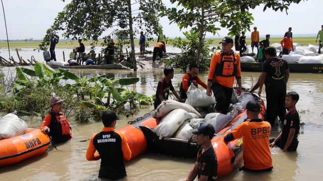 Petugas bersama warga saat perbaiki tanggul Kali Ingas di Desa Kedungprimpen, Kecamatan Kanor, Kabupaten Bojonegoro, yang jebol. Minggu (23/01/2022) (foto: dok istimewa)